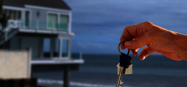 Uebersicht-Mehr-Wissen_Teaser-Ratgeber Nahaufnahme eines Schlüssels vor einem Haus am Meer